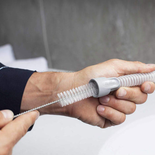 Stock Image of Person Cleaning Their CPAP Hose Tubing W/ CPAP Tubing Brush