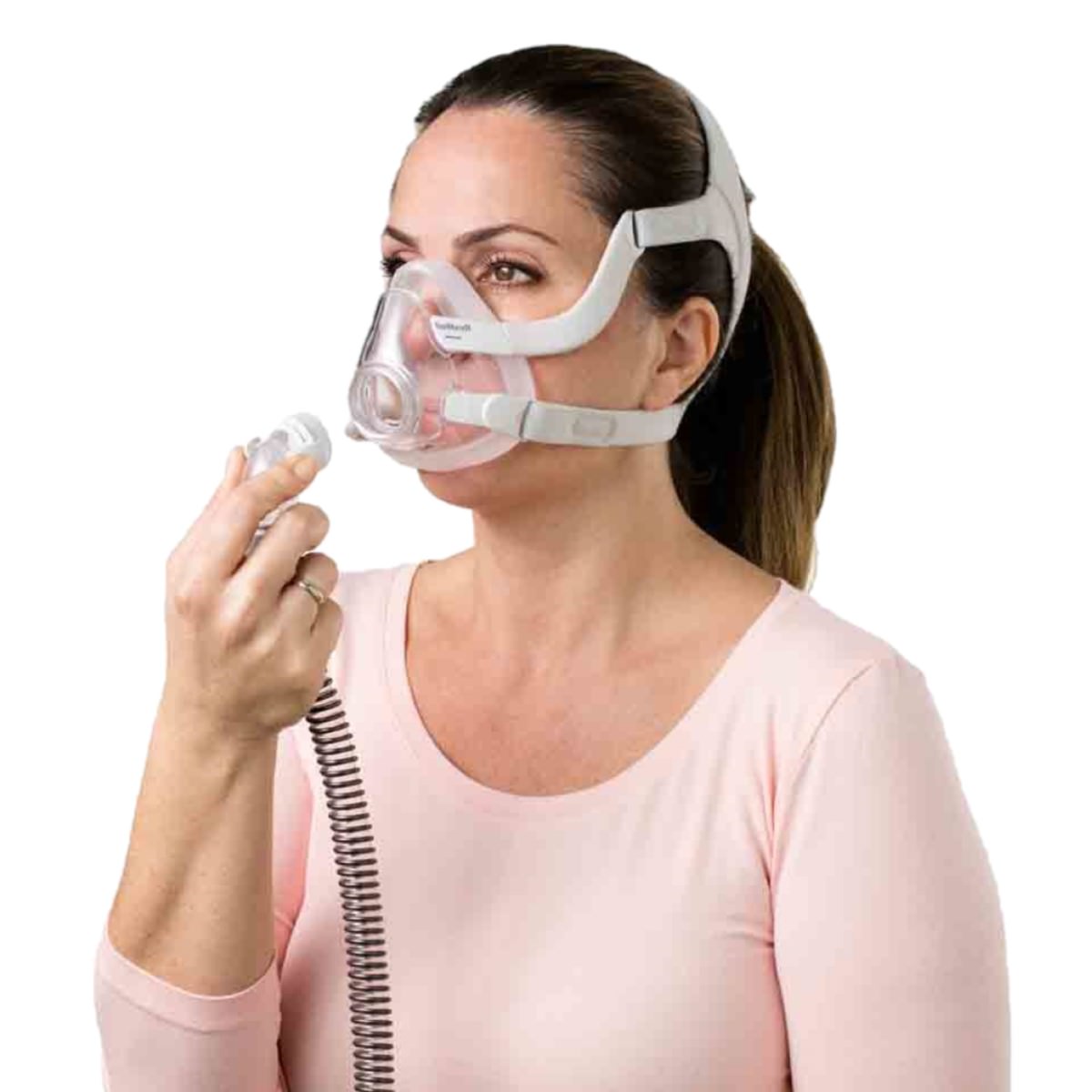 Stock Image of Woman Connecting Her CPAP Hose Tubing to Her Full Face CPAP Mask