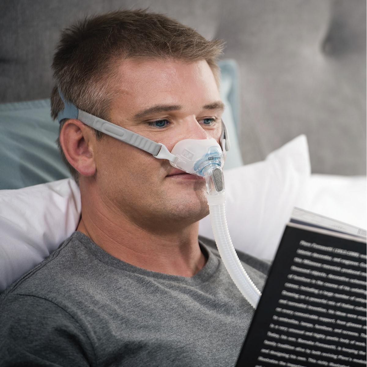 Photo of man wearing Fisher & Paykel Brevida nasal pillow CPAP mask with headgear