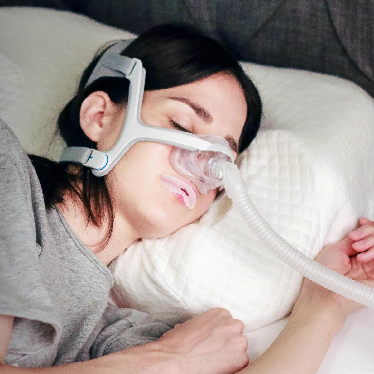 Stock Image of Woman Sleeping on Her Side Using Nasal CPAP mask W/ CPAPTape Mouth Tape for CPAP