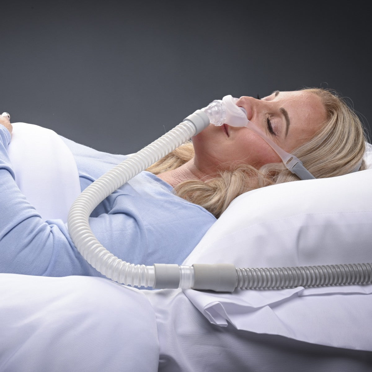 Stock Image of Woman Sleeping Supine Using REMSleep DeltaWave Nasal CPAP Mask W/ Headgear