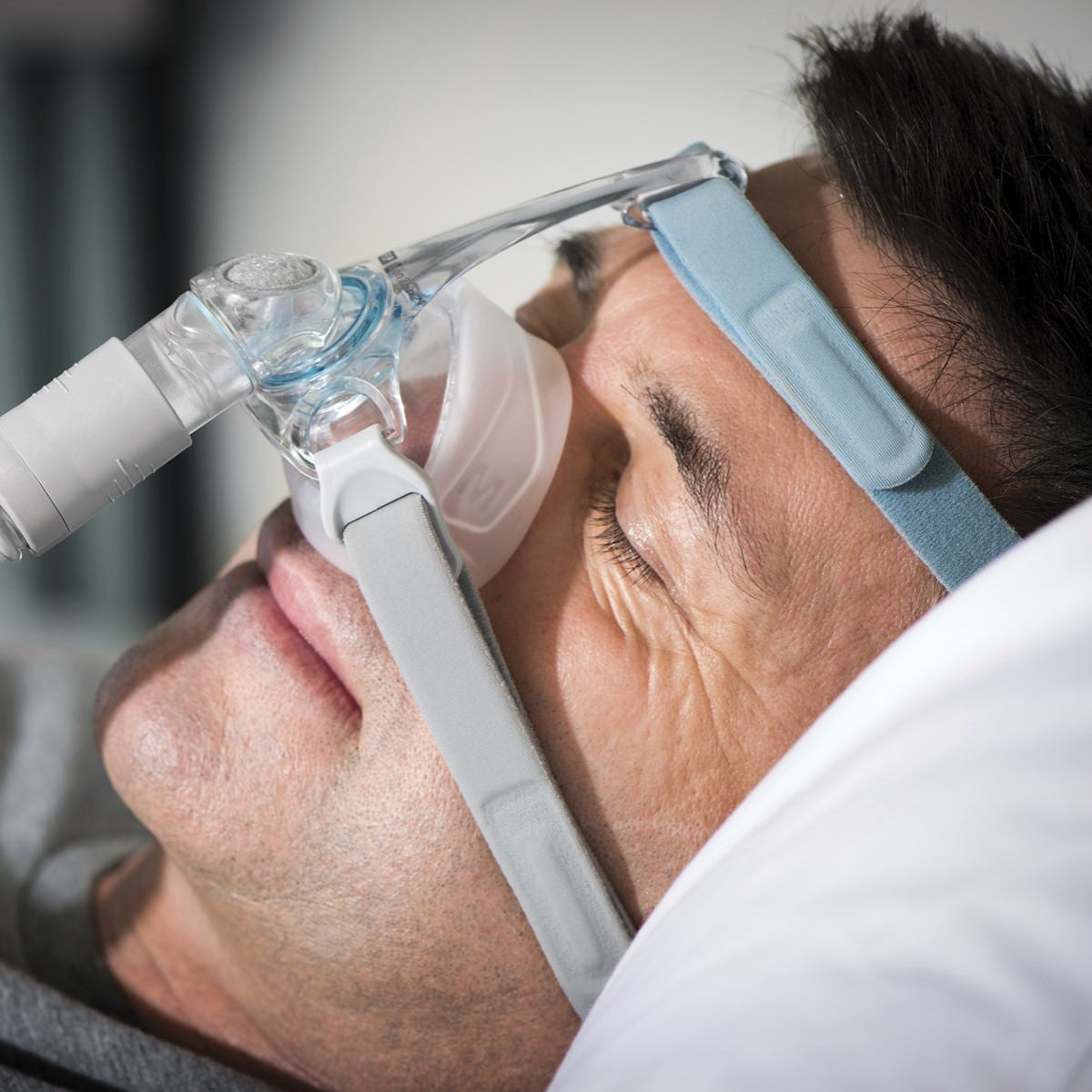 Photo of man using Fisher & Paykel Eson 2 nasal CPAP mask with headgear