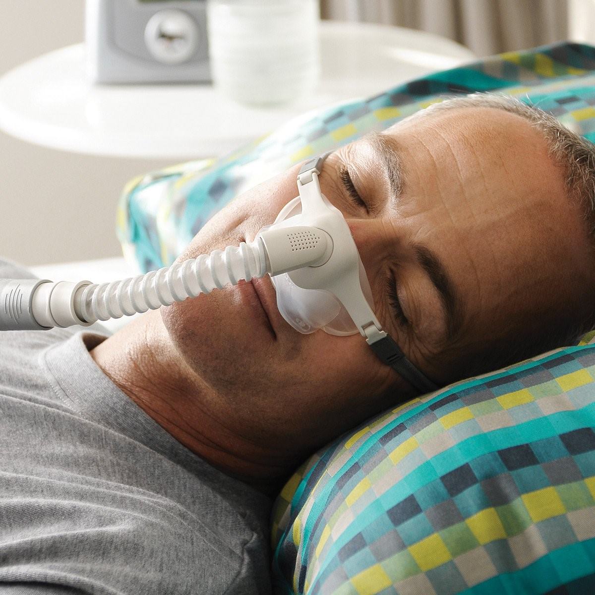 Photo of man using Fisher & Paykel Pilairo Q nasal pillow CPAP mask with headgear