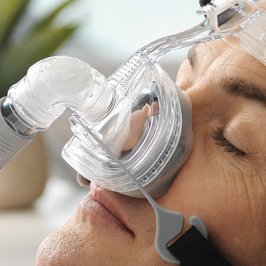 Photo of man using Fisher & Paykel Zest Q nasal CPAP mask with headgear