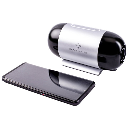 Stock photo of React Health Luna TravelPAP Auto CPAP machine next to phone