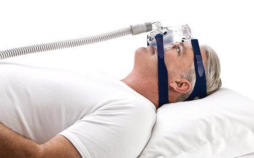 Stock photo of man using ResMed Mirage SoftGel nasal CPAP mask with headgear
