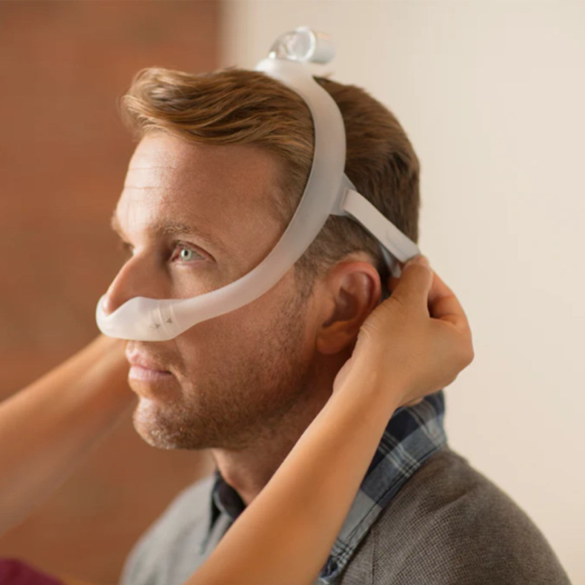 Stock Side Image of Man Getting Fitted for His Philips Respironics DreamWear Nasal CPAP Mask W/ Headgear