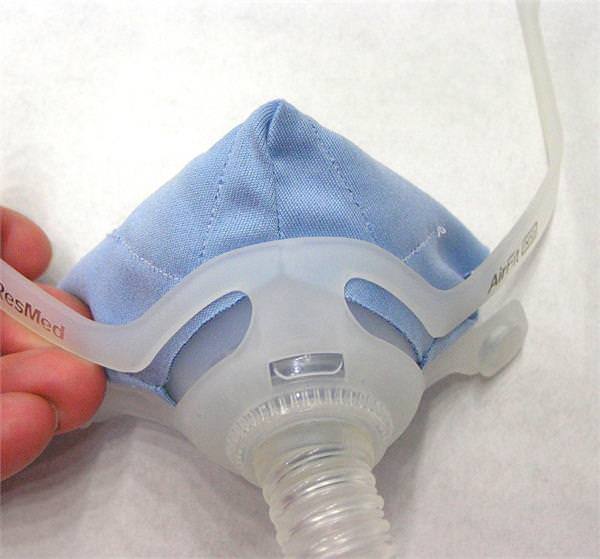 Photo of hand holding Pad A Cheek nasal CPAP mask liner for AirFit N10