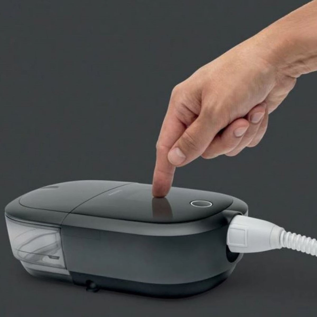 Stock photo of hand using Philips Respironics DreamStation 2 Auto CPAP machine