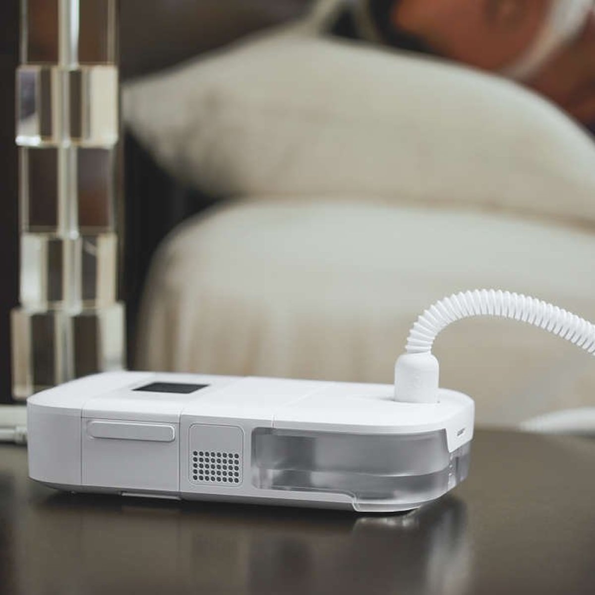 Photo of Philips Respironics DreamStation Go Auto Travel CPAP machine on nightstand