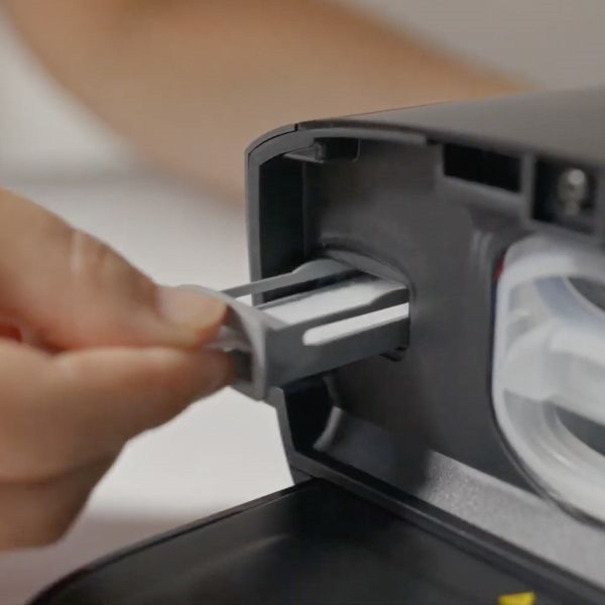 Photo of hand putting Philips Respironics DreamStation 2 Reusable Pollen filter into machine