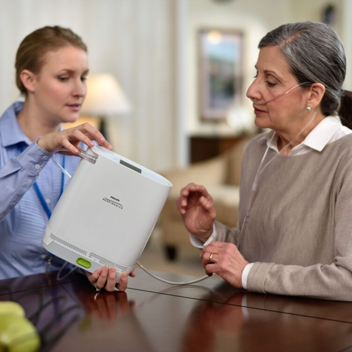 Photo of woman helping work Philips Respironics Certified Refurbished SimplyGo Mini Oxygen Concentrator