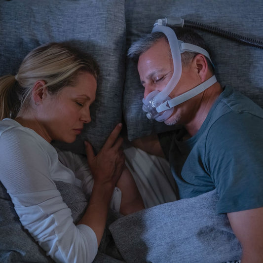 Photo of man sleeping while wearing ResMed AirFit F30i full face CPAP mask with headgear