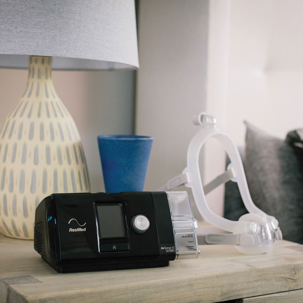 Photo of ResMed AirFit F30i full face CPAP mask kit on night stand next to CPAP machine