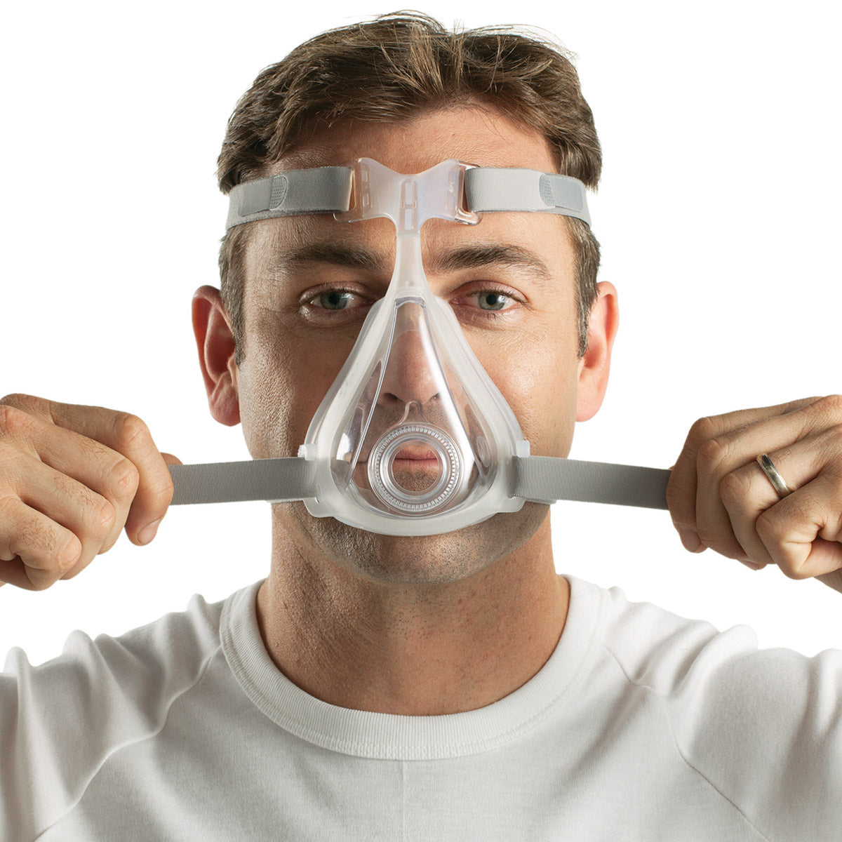 Forward facing man wearing ResMed Quattro Air full face CPAP mask tightening the headgear straps