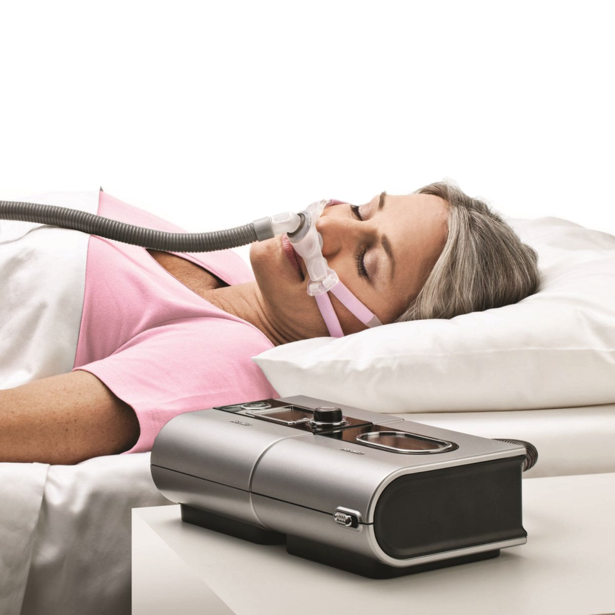 Stock photo of woman sleeping and wearing ResMed Swift FX Bella for her nasal pillow CPAP mask with headgear