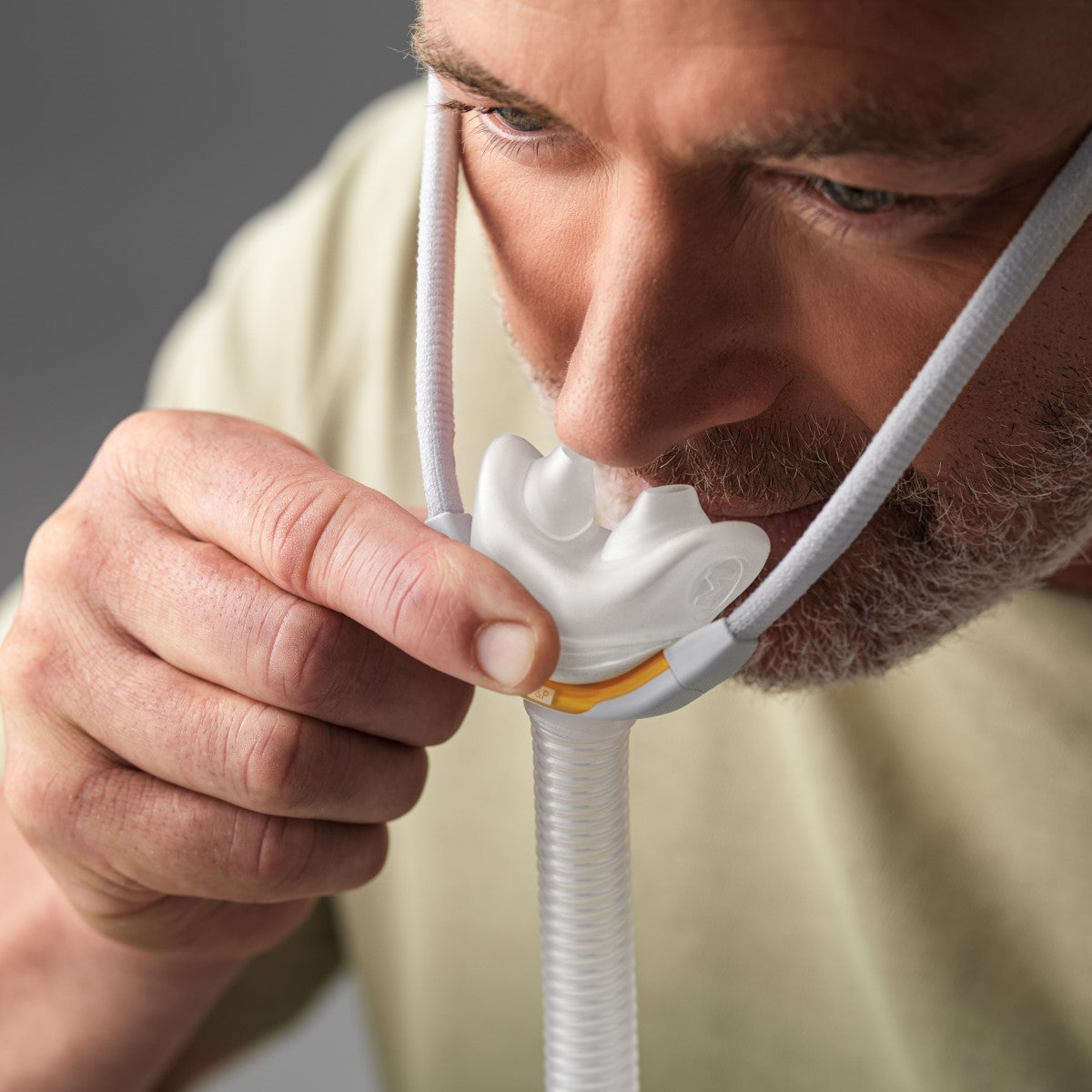 Man Fitting His Fisher & Paykel Solo Nasal Pillow CPAP Mask W/ Headgear