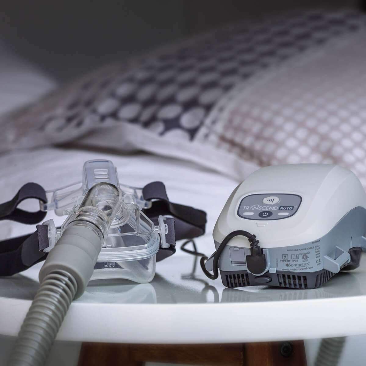 Photo of a certified refurbished Somnetics Transcend Mini Auto CPAP With EZEX CPAP machine next to mask