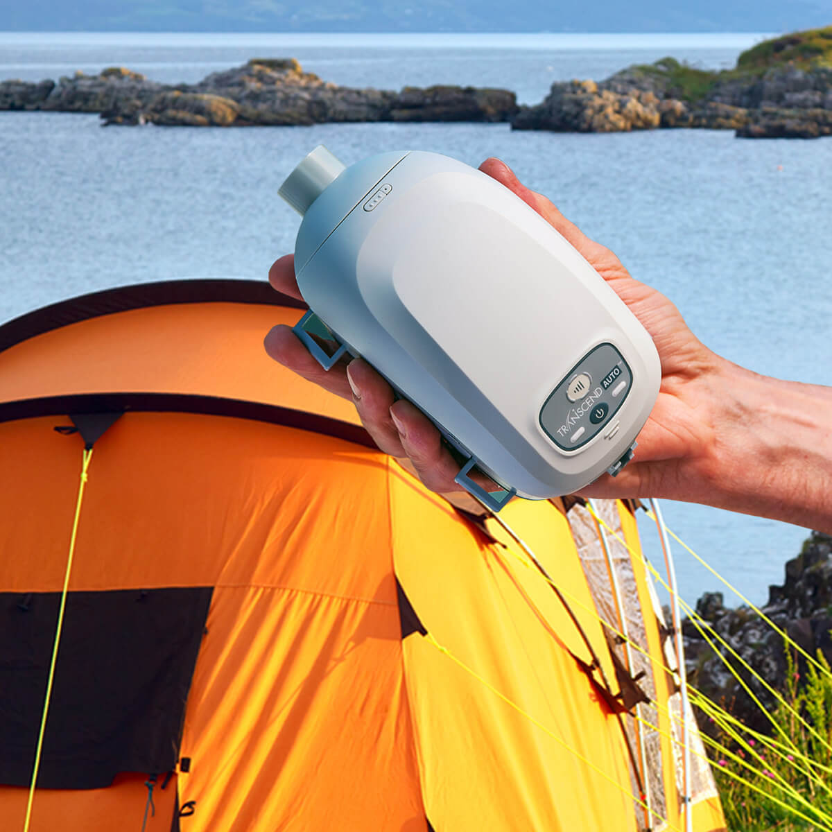 Person Holding Up Their Somnetics Transcend Auto CPAP Travel Machine