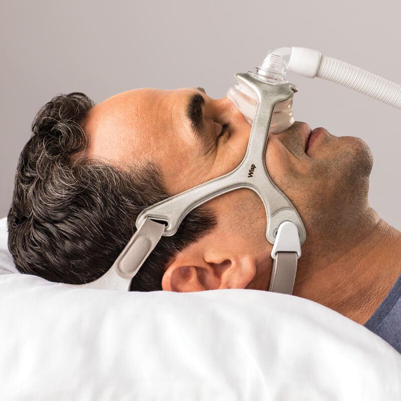 Man sleeping while wearing Philips Respironics Wisp fabric nasal CPAP mask fit pack with headgear