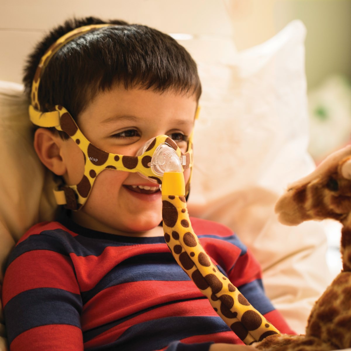 Left angled kid wearing a giraffe style Philips Respironics Wisp Pediatric nasal CPAP mask fit pack with headgear