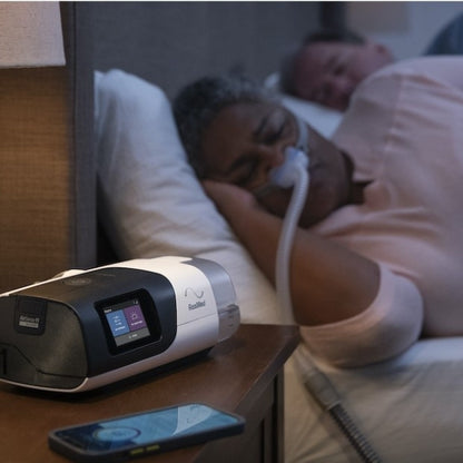 Wife Sleeping W/ Her ResMed Airsense 11 CPAP Machine next to Her Sleeping Husband