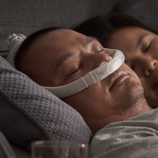 Man Using His CPAP Machine & Accessories While Sleeping With Partner in Bed
