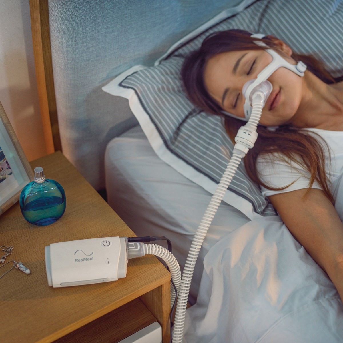 Stock Image of Person Sleeping Using their ResMed AirMini CPAP Device 