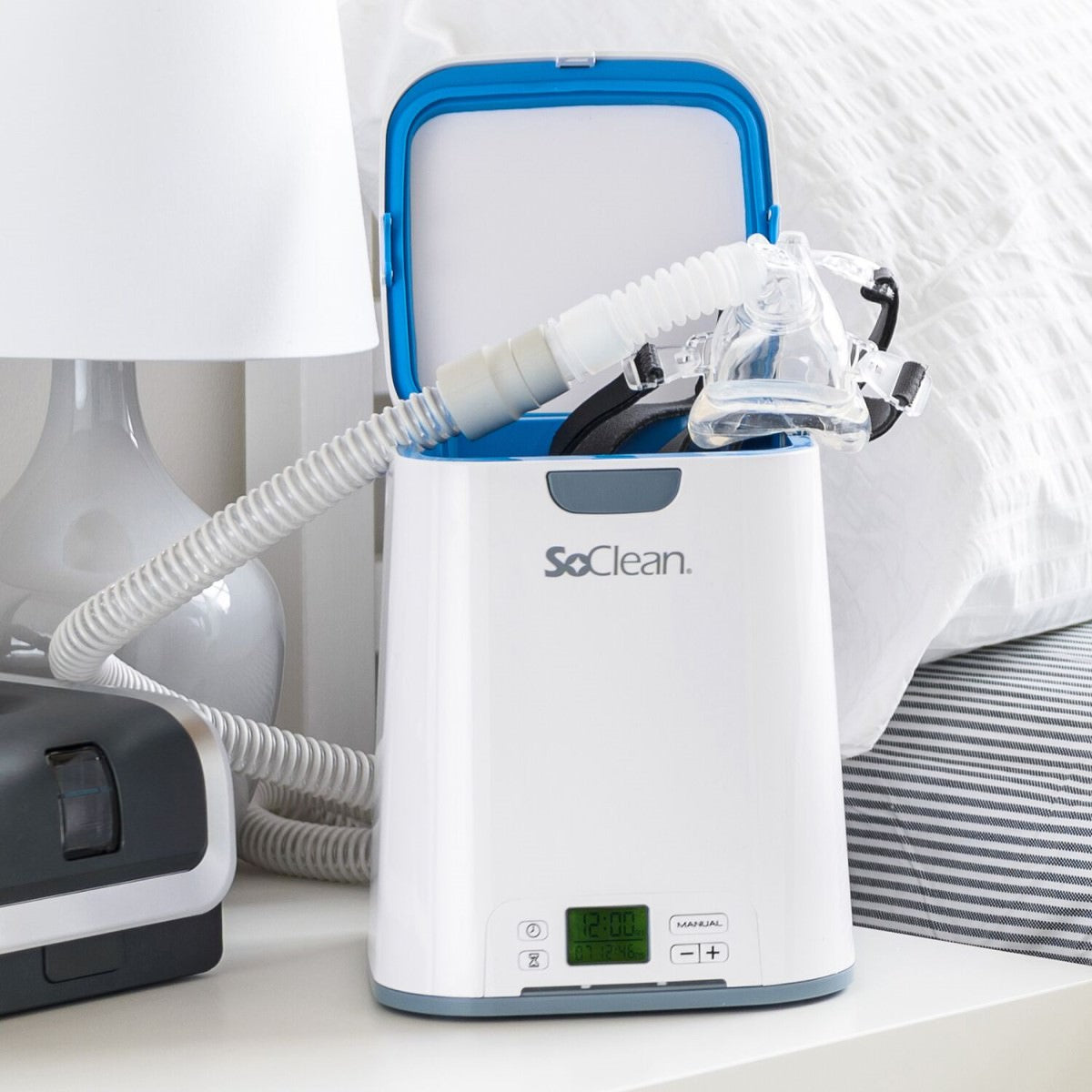 Photo of SoClean 2 CPAP Cleaner and Sanitizer on nightstand holding a CPAP mask and tubing