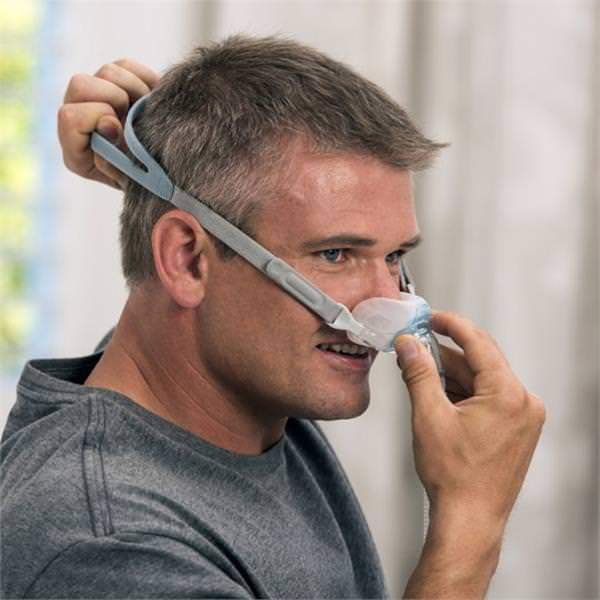 Photo of man wearing Fisher & Paykel Brevida nasal pillow CPAP mask with headgear