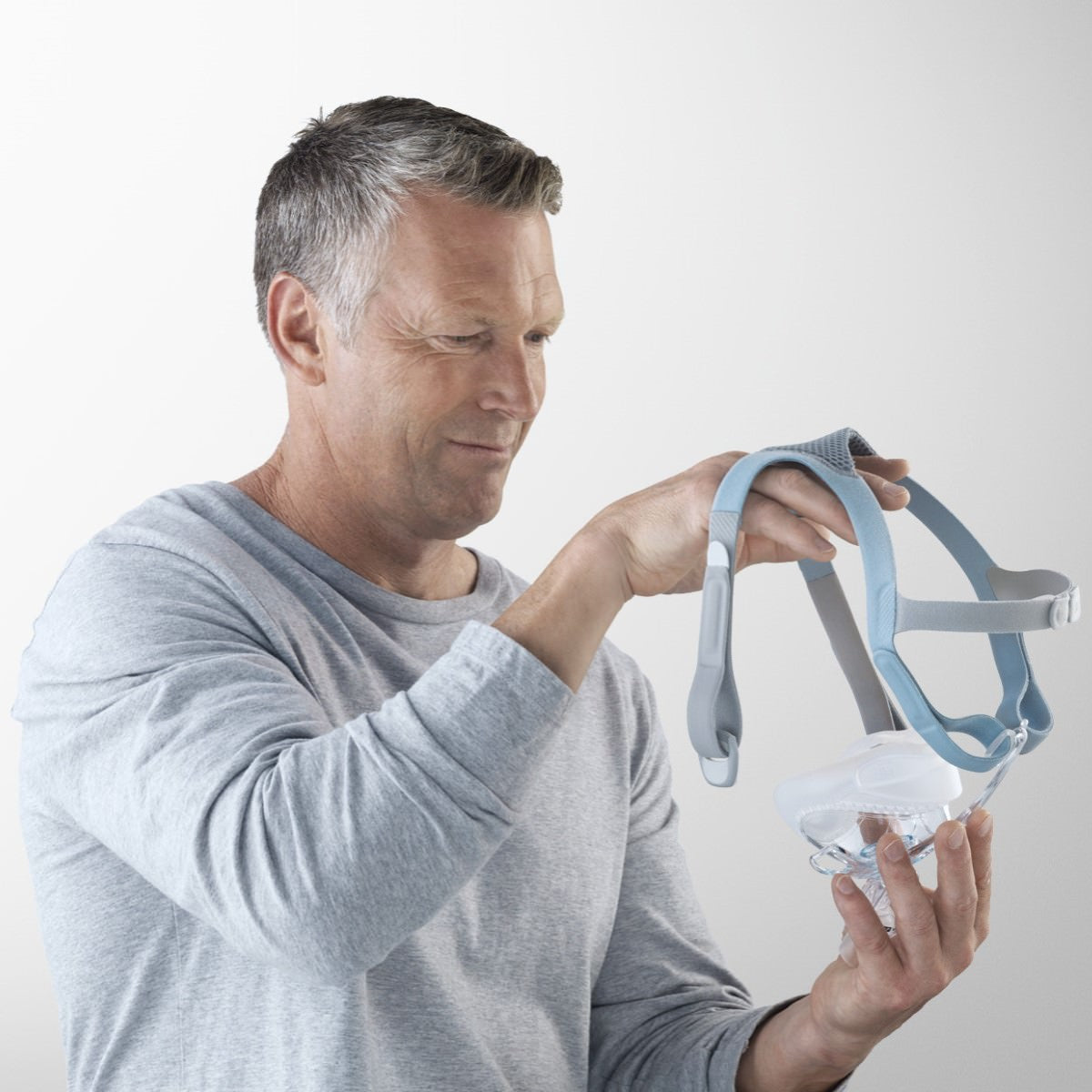 Stock Image of Man Fitting His Fisher & Paykel Vitera Full Face CPAP Mask W/ Headgear 