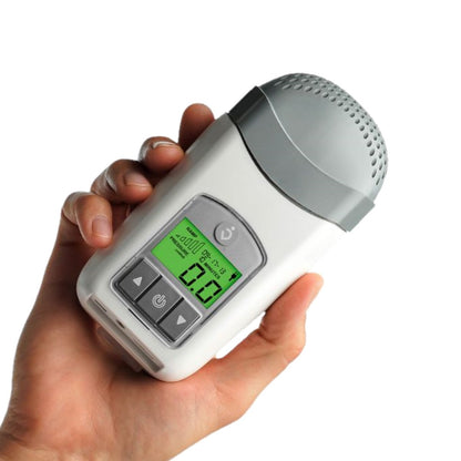 Stock photo of hand holding Human Design Medical Z1 Travel CPAP machine with PowerShell and battery