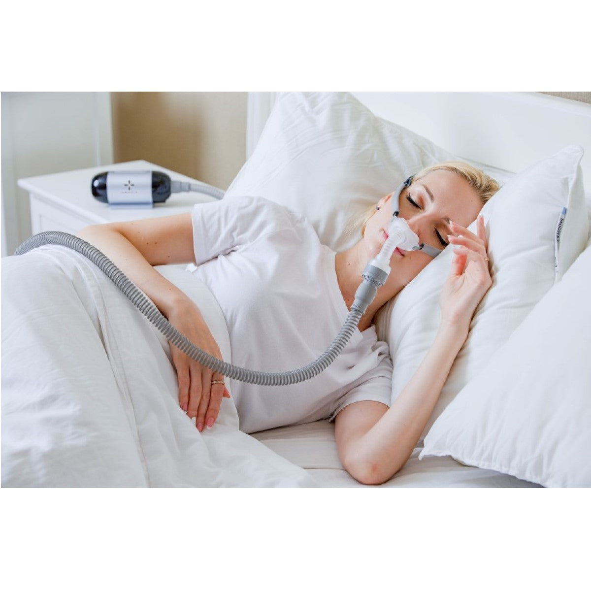 Stock photo of woman using React Health Luna TravelPAP Auto CPAP machine system