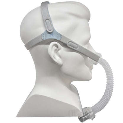 A side-profile view of a white mannequin head wearing a Nefes CPAP mask.