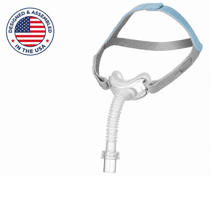 A sleep apnea mask with a clear mouthpiece tube, gray headband straps, and a light blue top strap, shown on a white background with a 'Designed & Assembled in the USA' badge in the top-left corner.