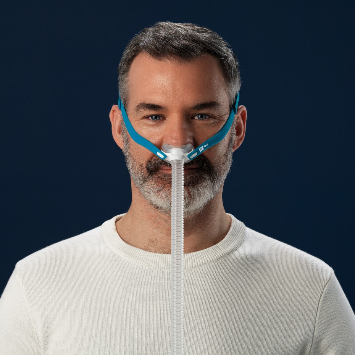 Stock photo of man wearing Fisher & Paykel Nova Micro nasal pillow CPAP mask with headgear