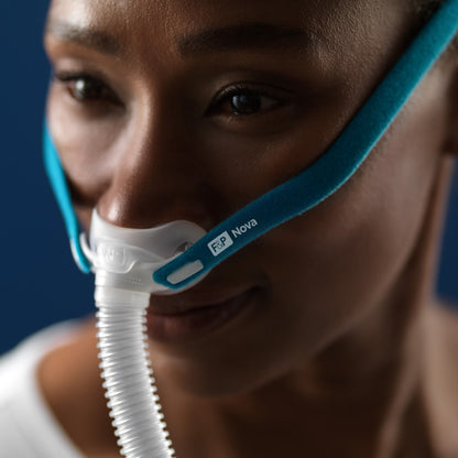 Photo of woman wearing Fisher & Paykel Nova Micro nasal pillow CPAP mask with headgear