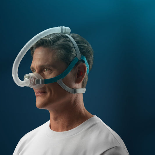 Man wearing a CPAP mask against a dark blue background
