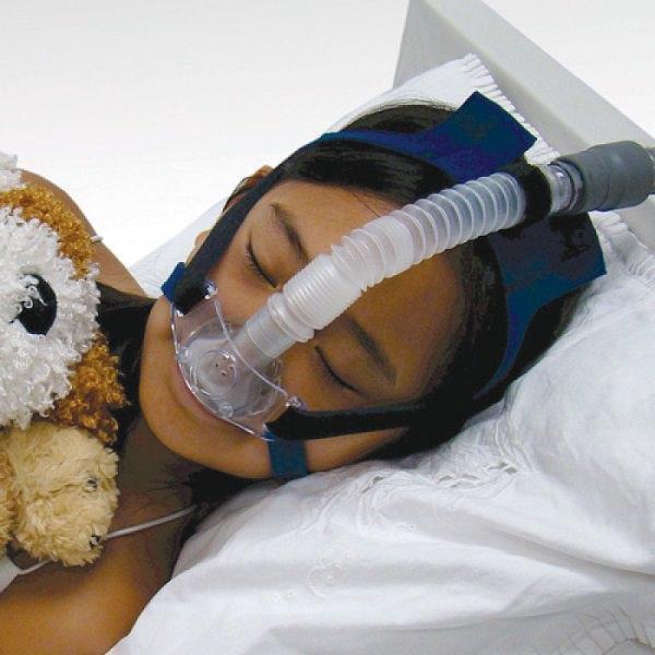Photo of kid using SleepNet Pediatric MiniMe nasal CPAP mask with headgear