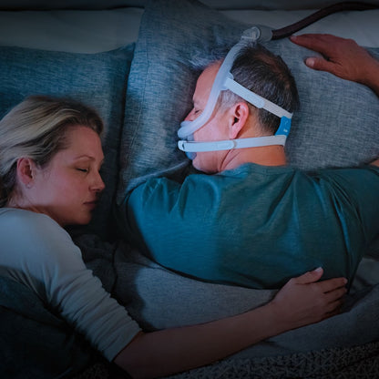 Man sleeping while wearing ResMed AirFit F30i full face CPAP mask with headgear