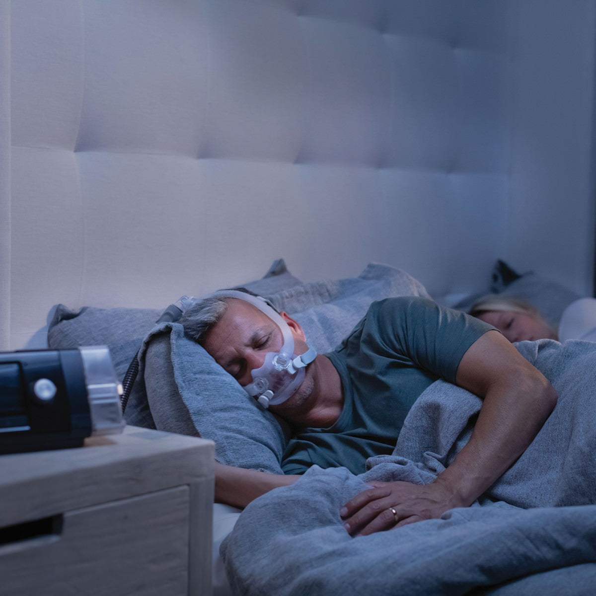 Man sleeping while wearing ResMed AirFit F30i full face CPAP mask with headgear