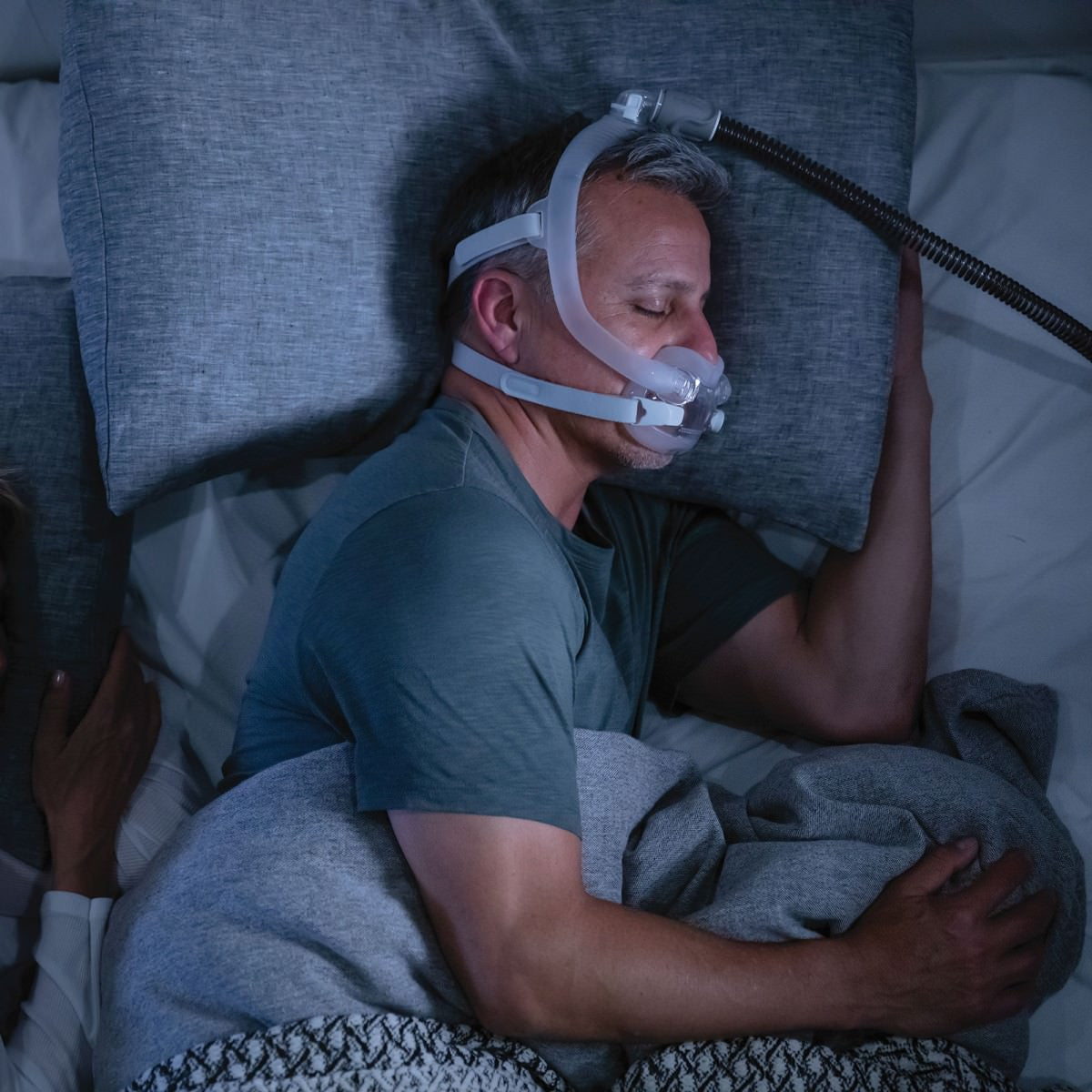 Photo of man sleeping with ResMed AirFit F30i full face CPAP mask with headgear