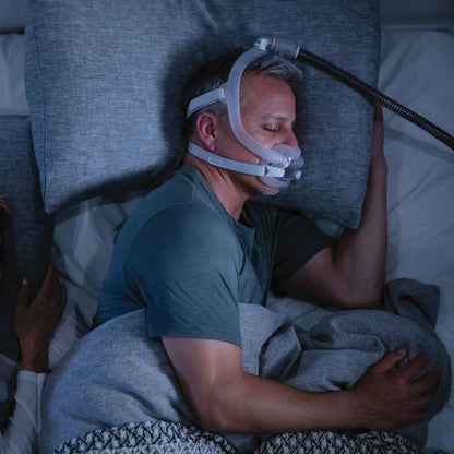 Photo of man sleeping with ResMed AirFit F30i full face CPAP mask with headgear