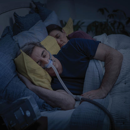 Man Sleeping Wearing His Nasal CPAP Mask Lying Next to His Partner