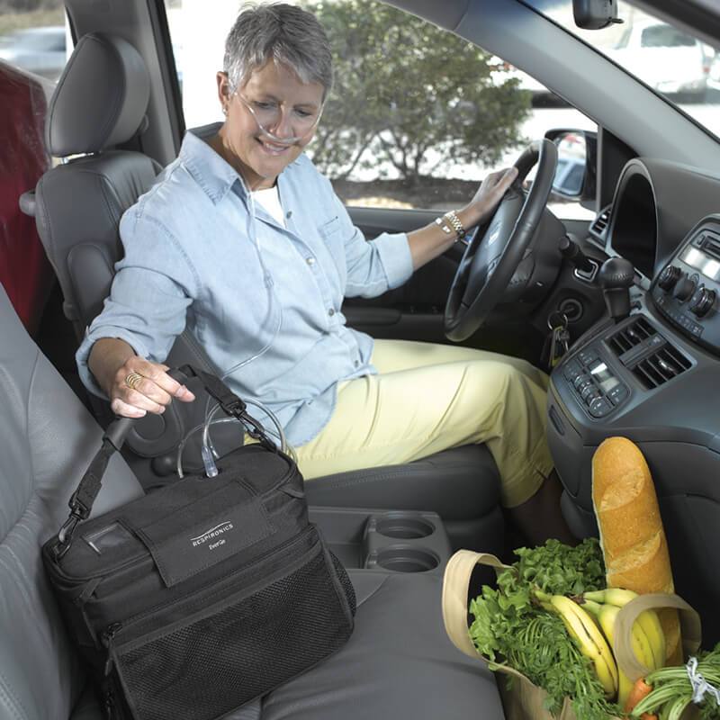 Photo of woman in car holding her Philips Respironics EverGo Portable Oxygen concentrator
