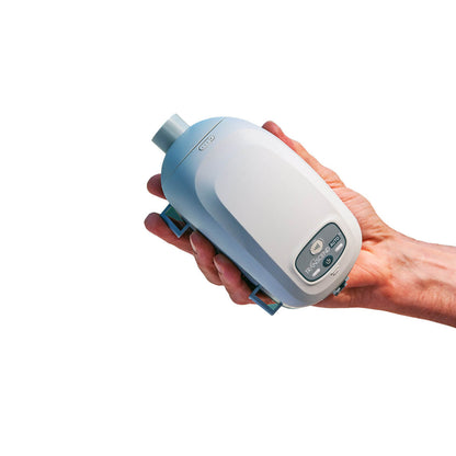 Stock photo of hand holding Somnetics Transcend Auto Mini CPAP machine