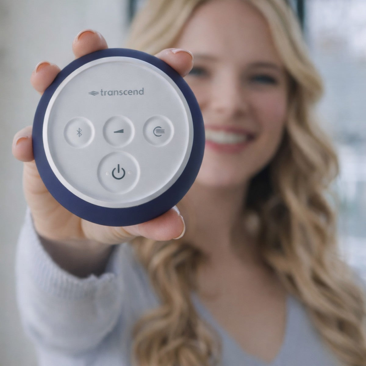 Person holding a round CPAP device with buttons, featuring the brand 'transcend'.