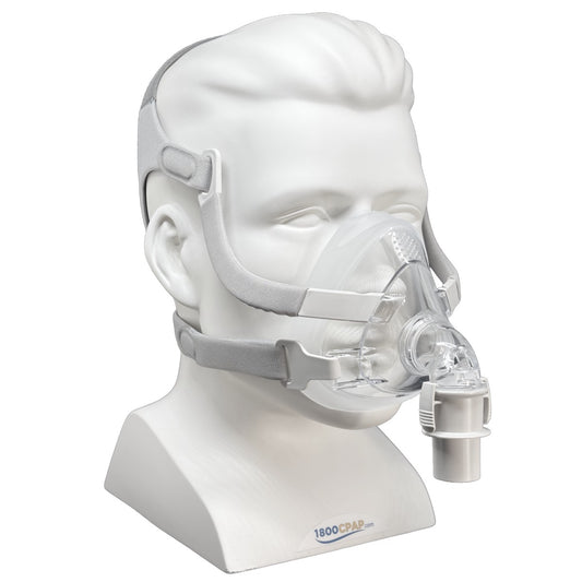 A clear CPAP mask with gray straps displayed on a white mannequin head and neck stand against a white background. The stand has the 1800CAP brand logo printed near the bottom.