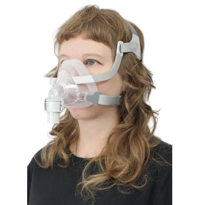 A person wearing a clear and light gray full face mask with an attached breathing tube, shown against a plain white background.